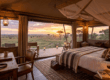 Luxury tented safari camp interior with a view over the Kenyan savannah at sunset